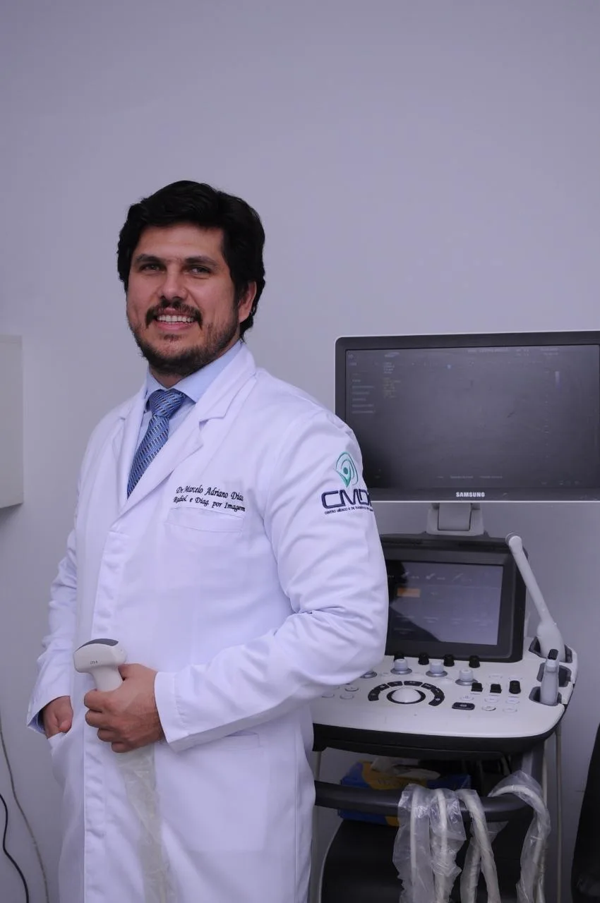 Dr. Marcelo Adriano Dias ao lado do aparelho de ultrassom